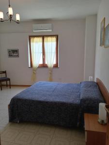 a bedroom with a blue bed and two windows at Casa vacanze al mare in Sardegna in Calasetta