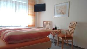 a bedroom with a bed and a table and chairs at Gästehaus Kiesgen-Mendgen in Bernkastel-Kues