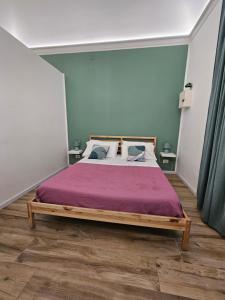 a bedroom with a large bed with a purple blanket at Sofia's Central Apartment Palermo in Palermo