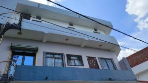 a white house with a blue wall at माँ विंध्यवासिनी होम स्टे कसया कुशीनगर in Kasia