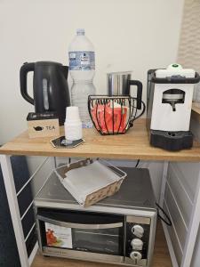 a shelf with a coffee maker and a microwave on it at Sofia's Central Apartment Palermo in Palermo