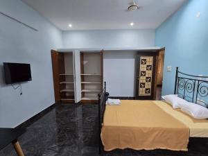 a bedroom with a bed and a flat screen tv at perumal home stay in Tiruvannāmalai