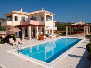 a villa with a swimming pool in front of a house at Villa Inn Messinia in Kalamaki Messinia