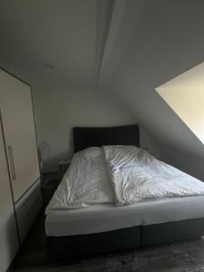 un letto non rifatto in una camera bianca di Schöne Ferienwohnung mitten in Fulda a Fulda