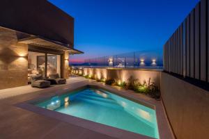 a swimming pool in the backyard of a house at night at Elements Collection in Khlóï