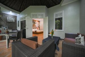 a living room with couches and a dining room at The Taman Ayu in Seminyak