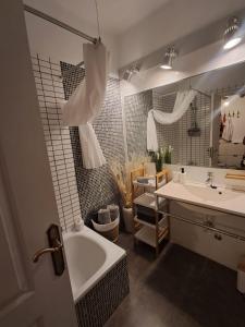 een badkamer met een bad, een wastafel en een spiegel bij Pool Terrace in El Médano