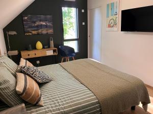 a bedroom with a bed and a desk and a window at Chambre du mont saint Michel in Bacilly