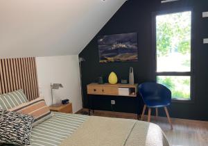 a bedroom with a bed and a desk with a chair at Chambre du mont saint Michel in Bacilly
