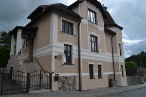 a brown and white building with a black fence at Pension Betty in Tábor