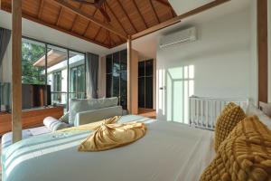a bedroom with a large white bed and a chair at V218 Brand New Near Best Beaches & Boat Avenue in Laguna Phuket +154 photos