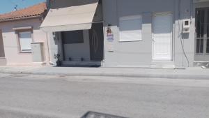 a white house with a white door on a street at MiniLoft apartment in Volos