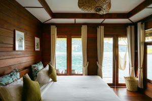 Un dormitorio con una cama grande en una habitación con ventanas. en Panvaree The Greenery, en Ban Chieo Ko