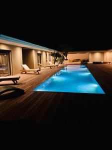 una grande piscina in un edificio di notte di Villa Toussaint a Pianottoli-Caldarello
