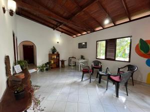 a living room with tables and chairs in a room at 'Kolamba Gedara' green apartment in Ruwanwella
