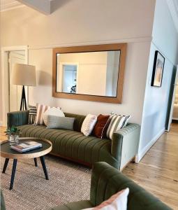 Una sala de estar con un sofá verde y una mesa. en Luxe, Style, Superb, Five Star, Stunning Home, en Dubbo