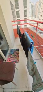 a balcony with mats and a chair on a building at Navi House-Pond Park AL Nahda in Sabkhah +8 photos