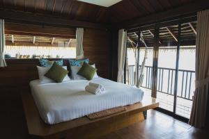 Un dormitorio con una cama blanca con una ventana grande. en Panvaree The Greenery, en Ban Chieo Ko