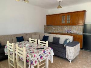 a kitchen and a living room with a table and a couch at Villa Reshat Caca in Ksamil