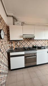 a kitchen with white appliances and a clock on the wall at Varanda do Coura in Caminha