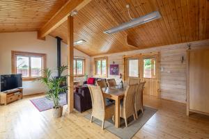 a living room with a wooden ceiling and a table and chairs at JEM Lodge in Stocksfield