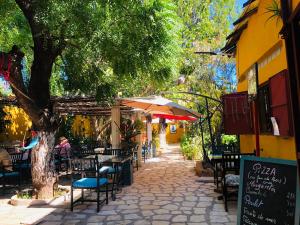 an outdoor cafe with tables and chairs and a tree at Hotel LE BOEUF in Mandriankeniheny