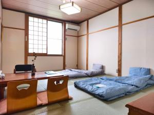 Camera con 2 letti, scrivania e tavolo. di 旅館青柳 海越し立山連峰の雪山絶景で休もう a Himi