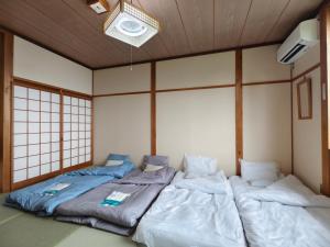 due letti singoli in una stanza con una parete di 旅館青柳 海越し立山連峰の雪山絶景で休もう a Himi