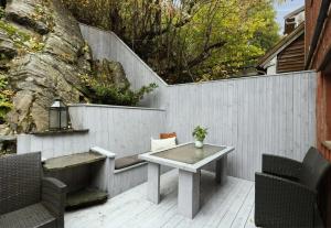 a patio with a table and chairs and a fence at Central and spacious 3-bedroom apartment in Mandal