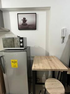 マニラにあるStaycation Condo - WiFi - Gym and Pool - 3 bedsの冷蔵庫付きのキッチンと電子レンジ付きのテーブル