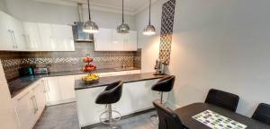 a kitchen with white cabinets and a table and chairs at Comfotel GRN in London