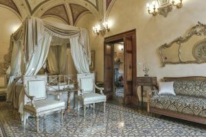 - un salon avec un canapé, une table et des chaises dans l'établissement Residenze d'Epoca Palazzo Coli Bizzarrini, à Sienne