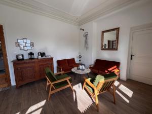 Una sala de estar con un sofá y sillas y una mesa. en Villa Marie Sete, en Sète