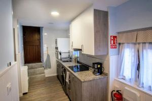 a kitchen with white cabinets and a counter top at SERENA Apartamento Cudillero in Cudillero +9 photos