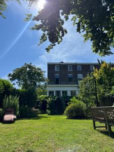 a building in a park with a bench in the grass at Studio Tuinzicht in Zutphen