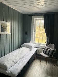 a bedroom with a bed and a window and a chair at Krossbu in Boverdalen