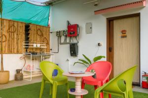 a room with three colorful chairs and a table at Lal Cottage in Jaipur