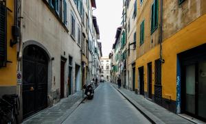 un callejón vacío con una motocicleta estacionada en el medio en Studio Santa Maria Novella, en Florencia