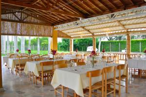 een feestzaal met witte tafels en stoelen met bloemen bij El Lugar Boutique Hotel in Pereira