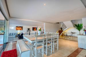 Búzios - Villa exceptionnelle في بوزيوس: غرفة طعام وغرفة معيشة مع طاولة وكراسي