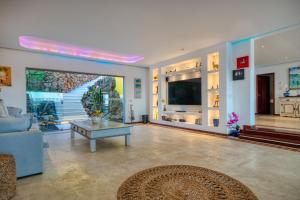 Búzios - Villa exceptionnelle في بوزيوس: غرفة معيشة بها أريكة وطاولة