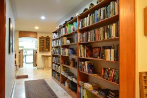 una biblioteca con estanterías de madera llenas de libros en El Lugar Boutique Hotel, en Pereira
