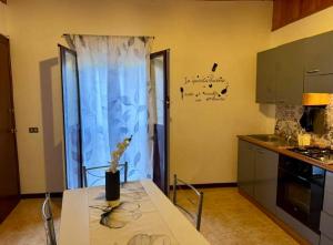a kitchen with a table with a vase on it at Mediterranea Apartment in Agrigento +17 photos