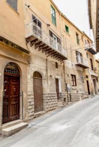 an old building with a wooden door on a street at Mediterranea Apartment in Agrigento