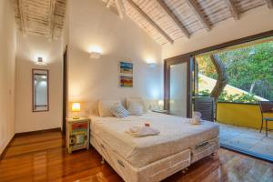 Búzios - Villa exceptionnelle في بوزيوس: غرفة نوم بها سرير ونافذة كبيرة +42 صورة