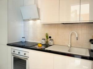 a white kitchen with a sink and a counter top at Holihome Mondo Serena in Tortoreto Lido