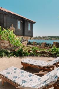 a patio with two lounge chairs and a house at The Greek House in Ahtopol
