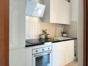 a kitchen with white cabinets and a sink at Holihome Mondo Serena in Tortoreto Lido