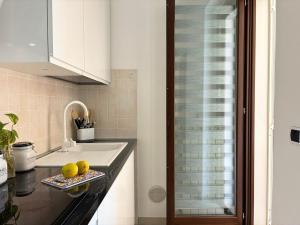 a kitchen with a sink and some fruit on a counter at Holihome Mondo Serena in Tortoreto Lido +37 photos