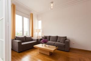 a living room with two couches and a coffee table at Nakos Homes Luxury Apartment-Acropolis Area in Athens